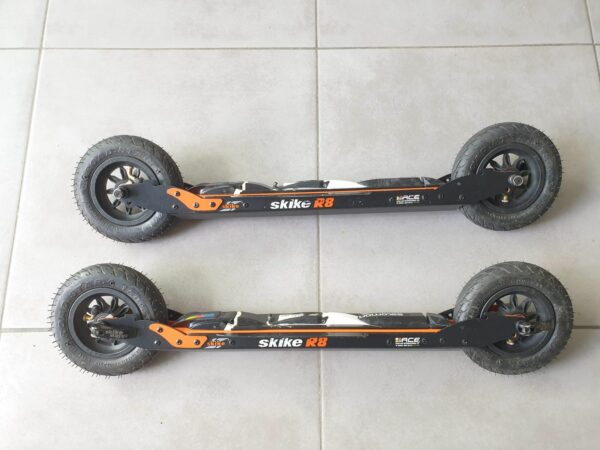 Une paire de ski-roues R8 WAHIA CROSS avec roues pneumatiques Ø 150 mm et système anti-recul sur les roues avant.